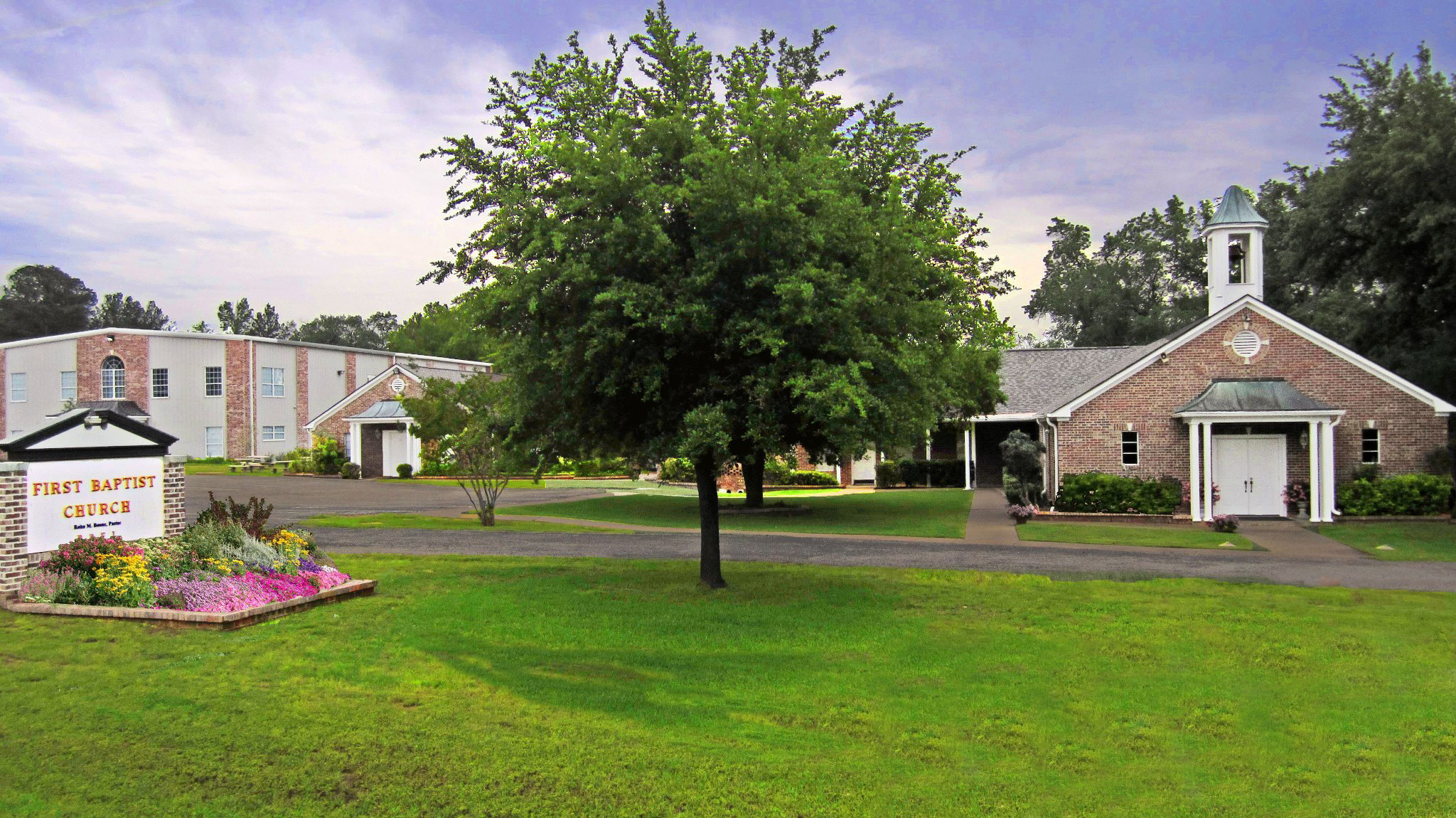 The brick sanctuary of First Baptist Church of Wright City with its landscaped front lawn