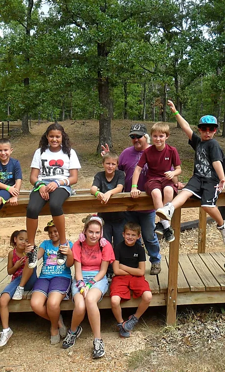 Youth group children together on an outdoor bridge at camp